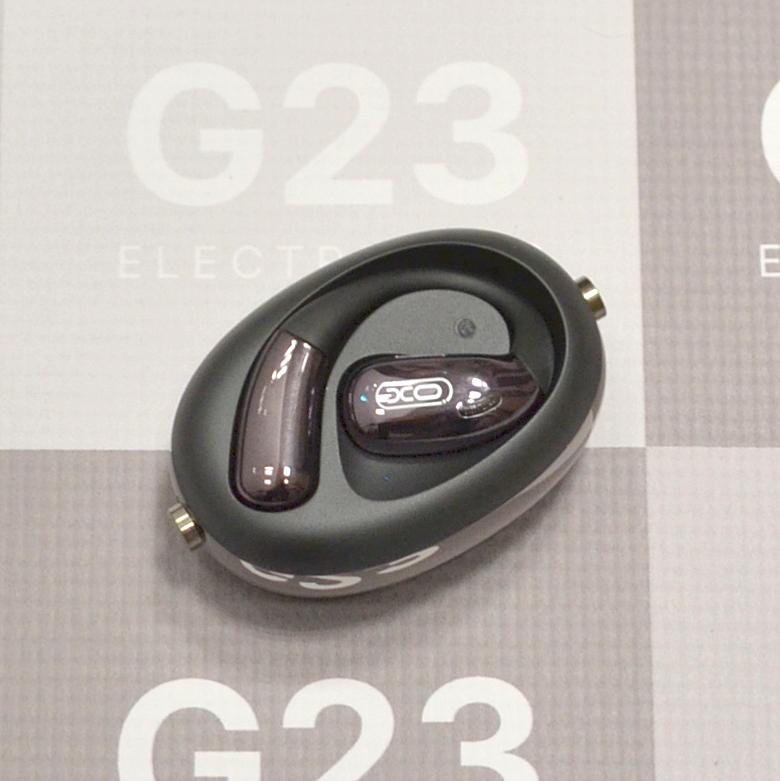 Bluetooth ausinės XO Open Ear su kabliais ausims juodos spalvos 9 XO Open Ear ausinių su kabliais ausims apvalus įkrovimo dėklas iš viršaus